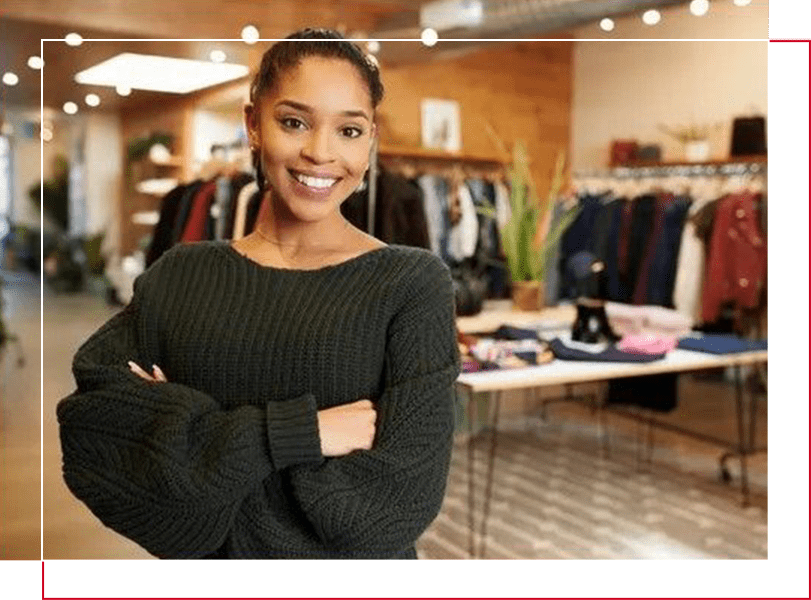 A woman standing in front of a table with clothes on it.