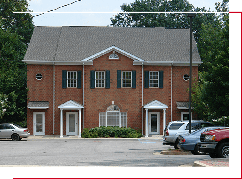 A brick building with cars parked in front of it.