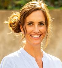 A woman with brown hair and a white shirt